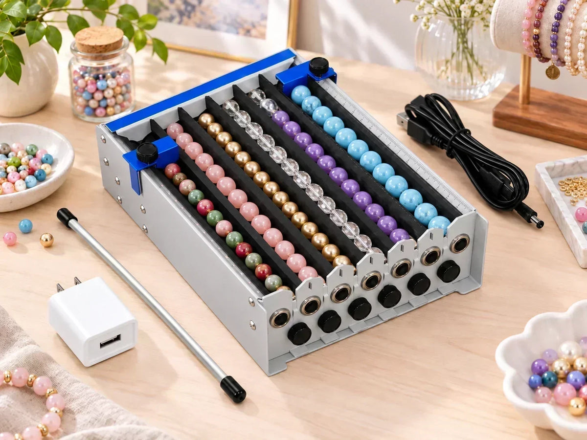 Six-channel bead threading machine with colorful beads and USB power cable on a jewelry workbench.