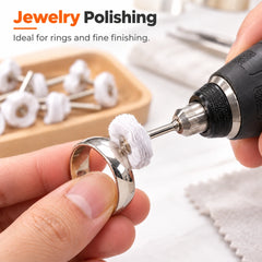 Polishing a silver ring with a white cloth wheel on a rotary tool