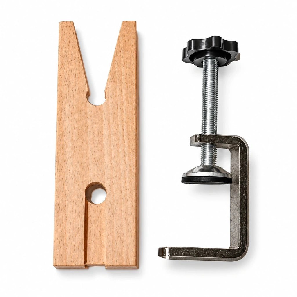 Wooden jewelry bench pin with V shaped notch and adjustable metal table clamp on a white background.